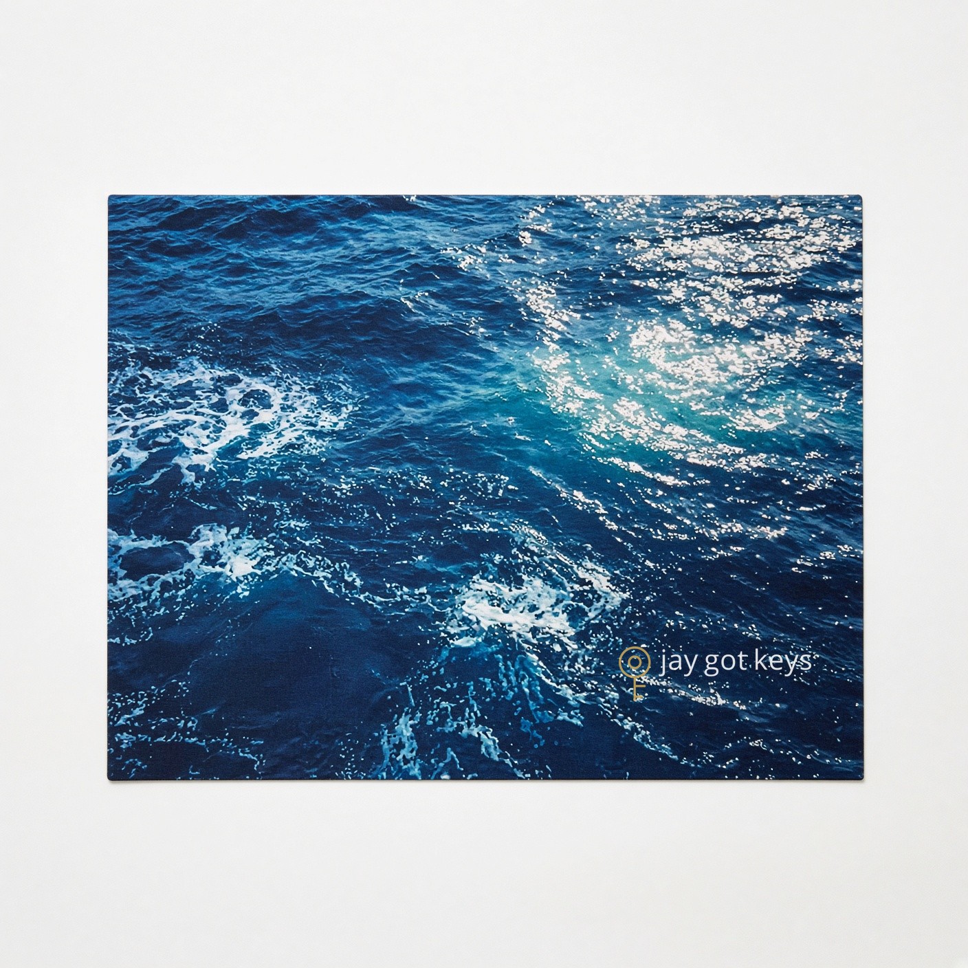 Ocean water mouse pad with jay got keys logo in the bottom right